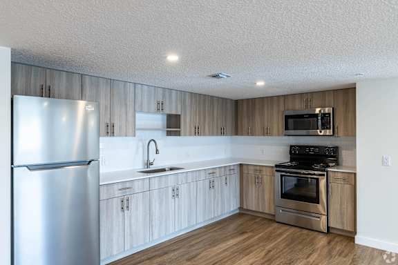A modern kitchen with wooden cabinets and stainless steel appliances.