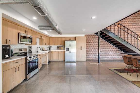 A kitchen with wooden cabinets and a stainless steel refrigerator.