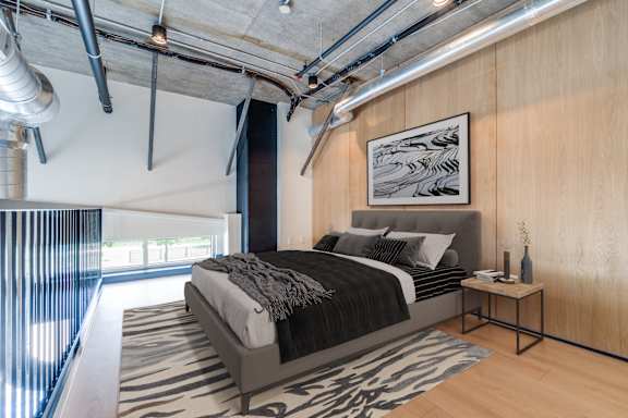 A bedroom with a large bed and a small table.