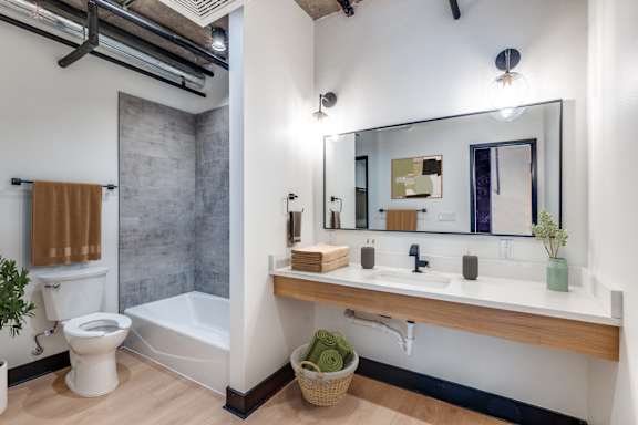 A bathroom with a toilet, sink, and mirror.