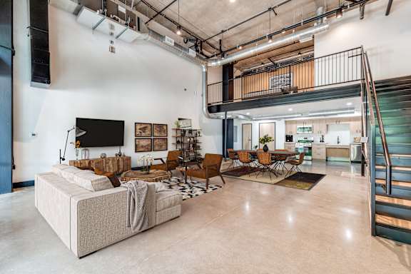 A living room with a couch, chairs, and a television.
