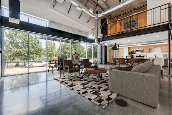 A living room with a couch, chairs, and a rug.