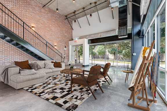 A living room with a couch, chairs, and a rug.