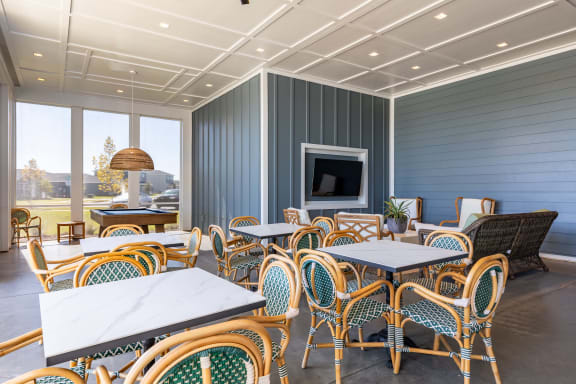 Clubhouse with wooden tables, chairs, and a TV.