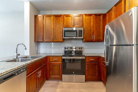 a kitchen with stainless steel appliances and wooden cabinets