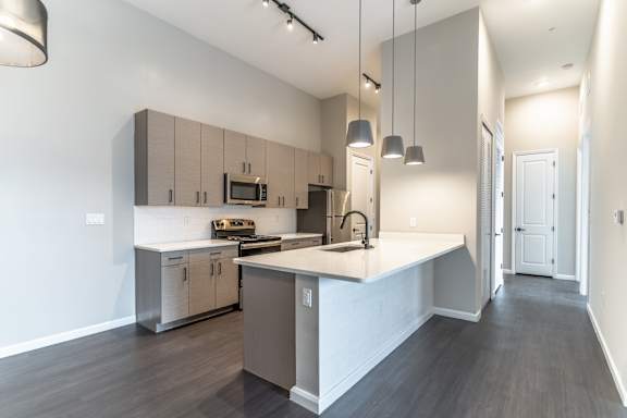 A modern kitchen with a large island and stainless steel appliances.