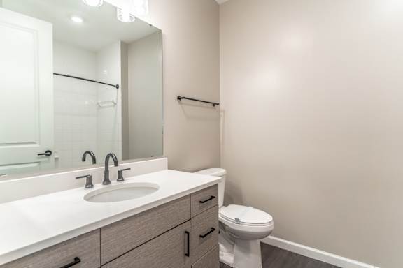 A white sink with a silver faucet and a white toilet in a bathroom.