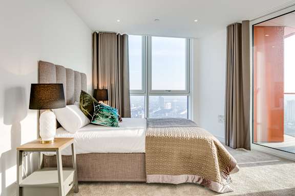 a bedroom with a bed and a large window