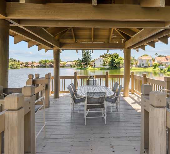 A wooden deck with chairs overlooking a body of water.