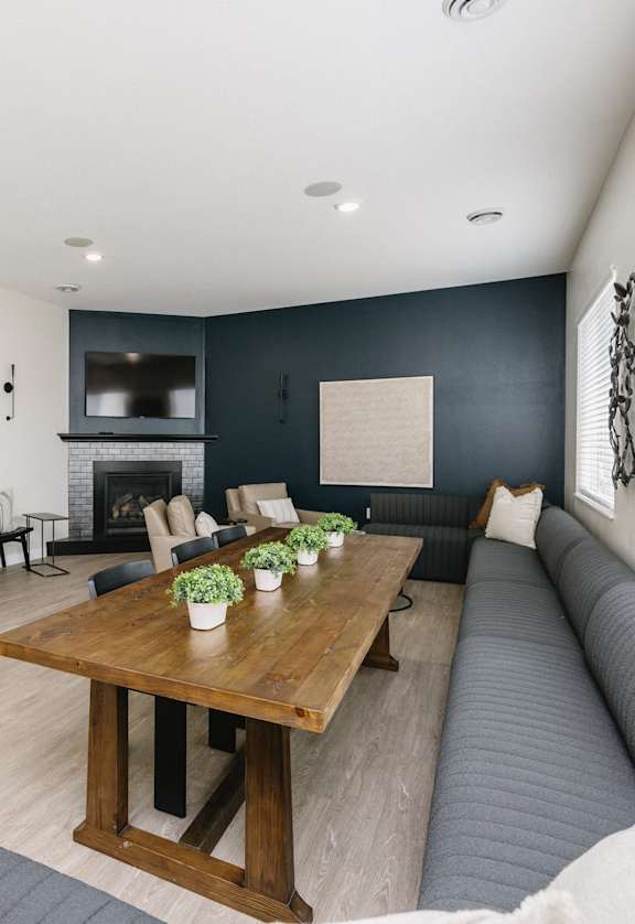A modern living room with a wooden table and grey couch.
