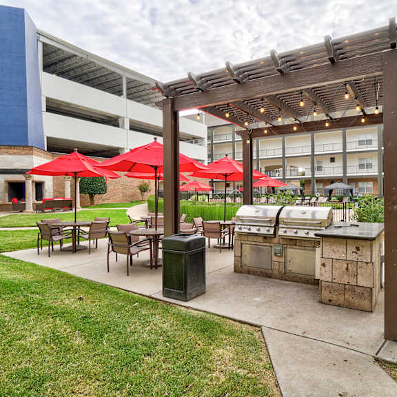 Grilling area outside with patio tables and chairs at Aviare Arts District.