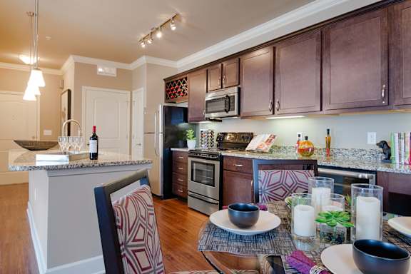 Gourmet kitchen with stainless steel appliances, granite countertops, and dining area  at Residences at Prairiefire Apartment Homes, Overland Park, 66223