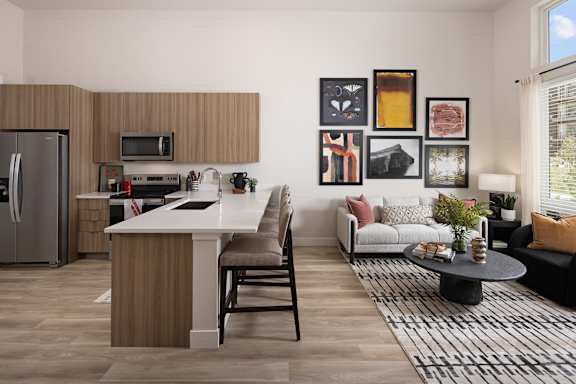 A modern kitchen with a refrigerator, microwave, and a dining table with chairs.