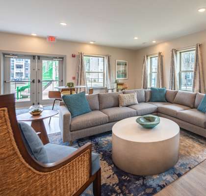 A living room with a grey couch and a wooden chair.