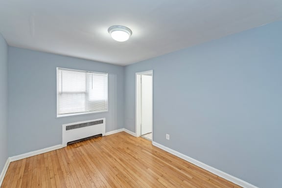 a bedroom with hardwood floors and blue walls
