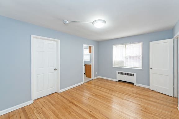a bedroom with hardwood floors and blue walls