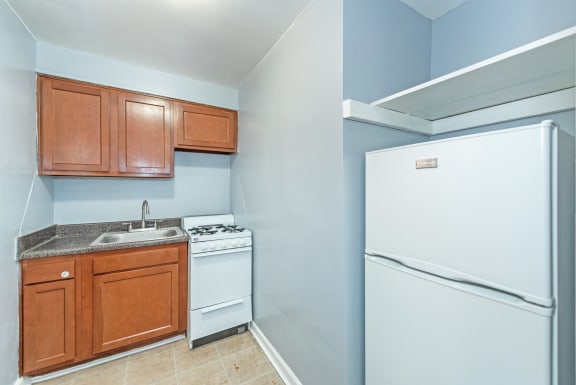 a kitchen with a white refrigerator freezer next to a stove top oven