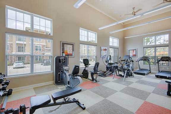 Spacious fitness center at Residences at Prairiefire with cardio machines, weight equipment, and large windows for natural light. at Residences at Prairiefire Apartment Homes, Overland Park, Kansas