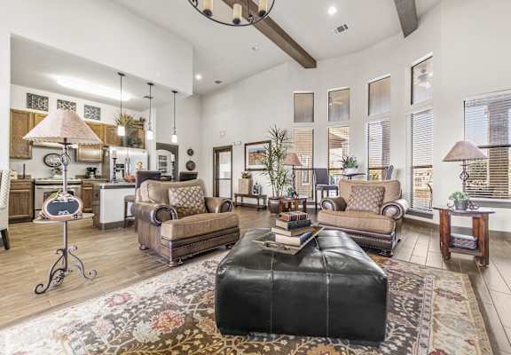 a living room with a leather ottoman and a leather couch
