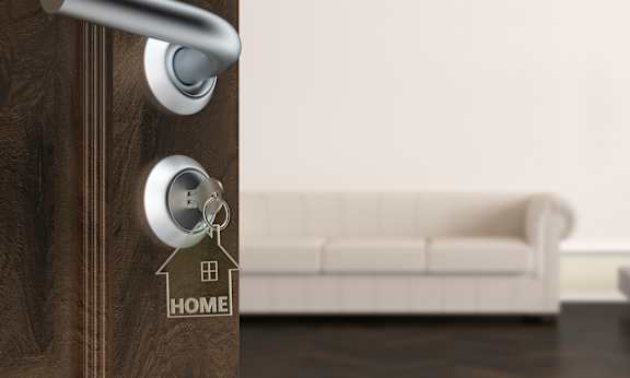 A modern door handle with a keyhole and a key on a wooden door.