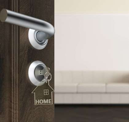 a door with a key in the door handle with a house keychain on it
