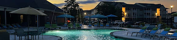 a swimming pool at dusk at The Madison Apartment Homes in Tyler, TX 75703