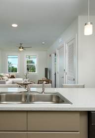 A modern kitchen with a large island and a stainless steel sink.