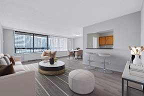 A modern living room with a large window and a bar area.