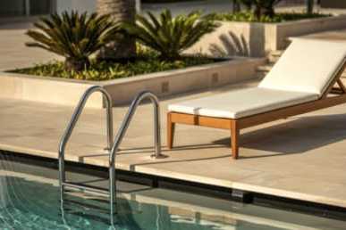 A poolside lounge chair is positioned on the edge of a pool at Masselin Park West, California, 90036