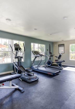 the gym has plenty of exercise equipment and a tv at Vineyard Terrace Apartments, Napa, CA
