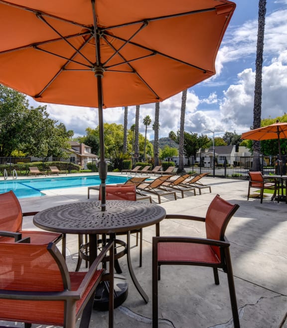 a patio with tables and umbrellas next to a swimming pool at Vineyard Terrace Apartments, Napa, California