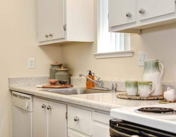 a kitchen with white cabinets and white appliances at Renaissance Park Apartments, California, 95618