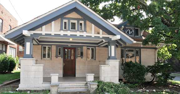 A small house with a brown door and a porch.