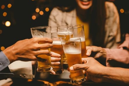 A group of people toasting with beer glasses.