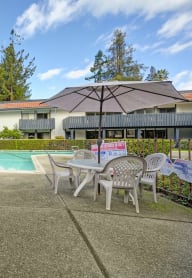 a swimming pool with tables and chairs and umbrellas