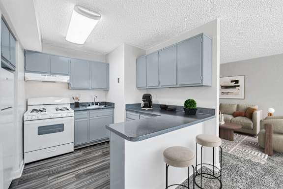 A kitchen with a black countertop and white cabinets.