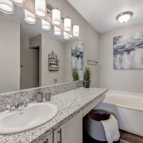 a bathroom with a sink and a tub and a mirror at Desert Bay Apartments, Laughlin, NV, 89029