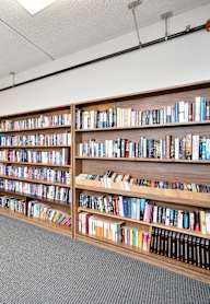 a library with a table and chairs and shelves of books