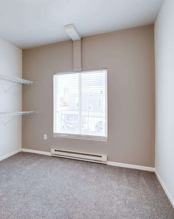 an empty room with a large window and wooden floors