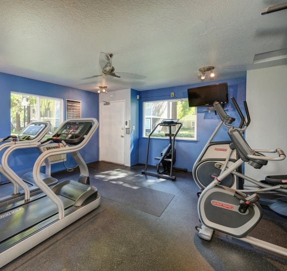 Gym has plenty of cardio equipment and a tv at Rush River Apartments, California