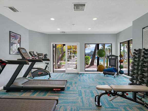 A gym with treadmills, exercise balls, and a bench.