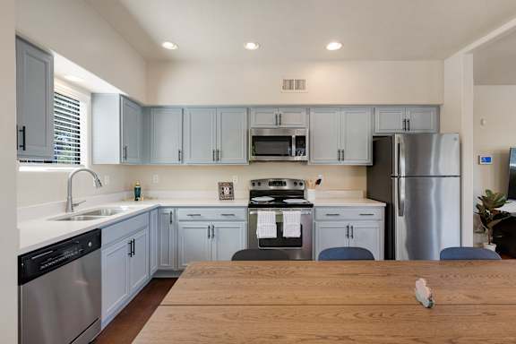A kitchen with a wooden table in front of it.