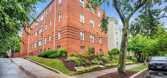 exterior view of a red brick apartment building on a rainy day