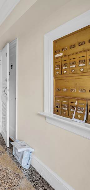 the hallway of a house with white doors and a tiled floor
