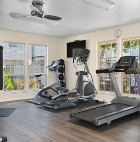 two treadmills and other exercise equipment in a gym with windows  at Cobblestone Creek Apartments, Roseville, CA, 9566