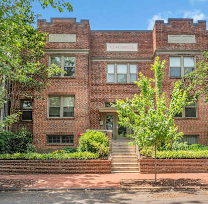 front view of a red brick building with stairs in front