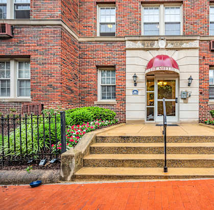 the front of a brick building with steps and a door