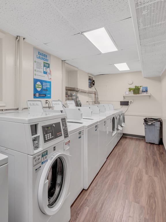 a laundromat with four washers and four dryers in a room with