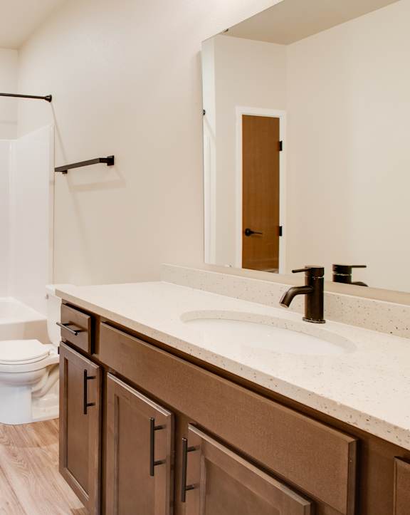 A bathroom with a toilet, sink, and bathtub. at Augusta Apartments, Fargo, ND, 58104