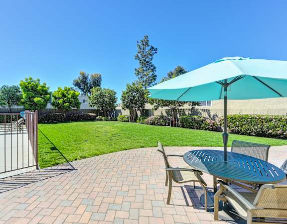 a patio with a table and chairs and a swimming pool